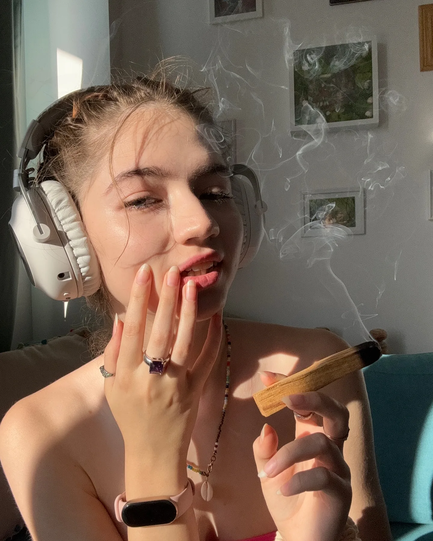 Young woman with headphones smoking a cigar indoors